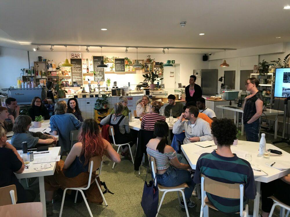 A cafe space filled with people listening to a talk