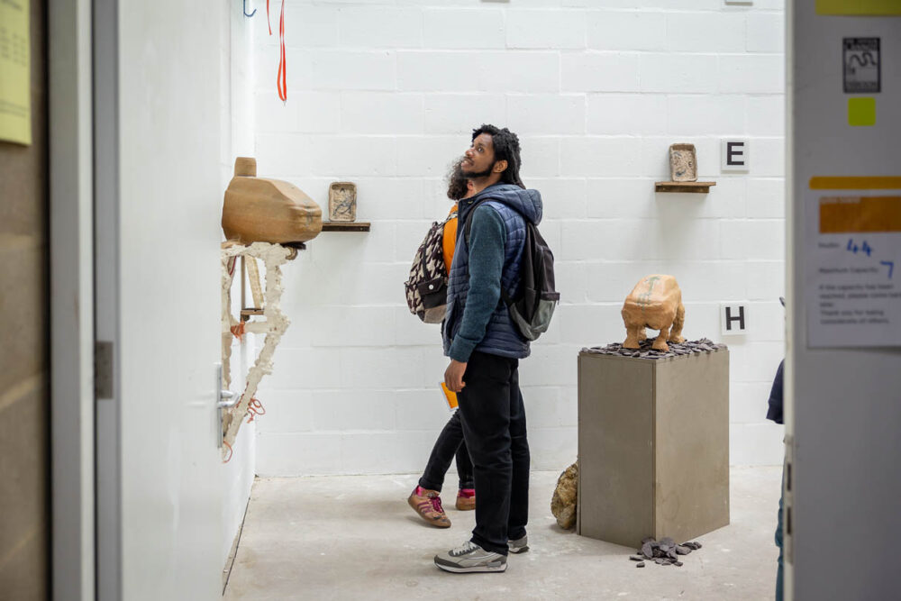 A photograph of a man looking at artworks in Spike Island's Open Studios 2022.