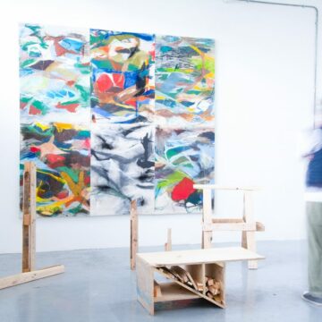 An installation featuring wood offcuts and a painting in the background