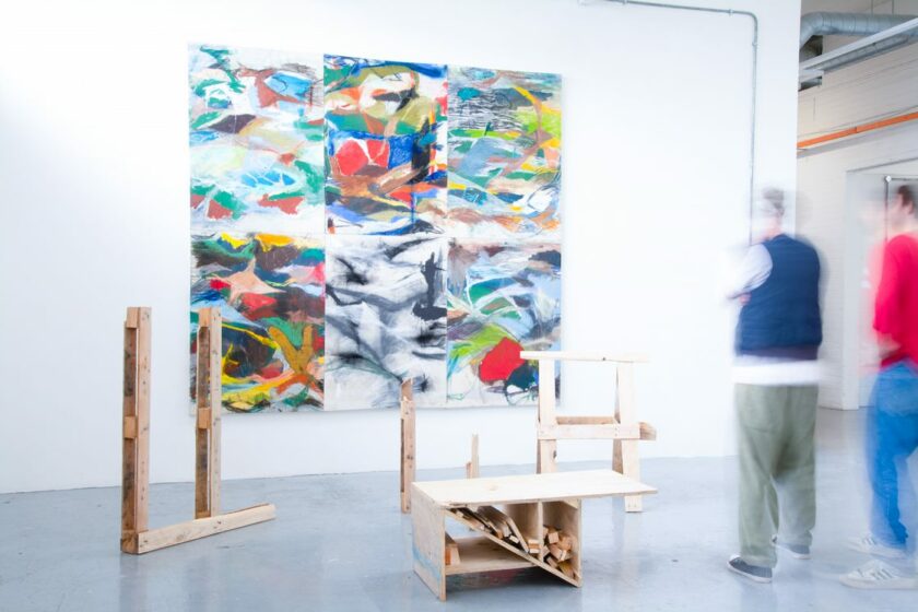 An installation featuring wood offcuts and a painting in the background