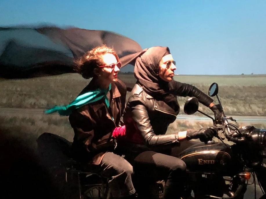 Florence Fitzgerald-Allsopp and Cigdem Aydemir riding a motorbike